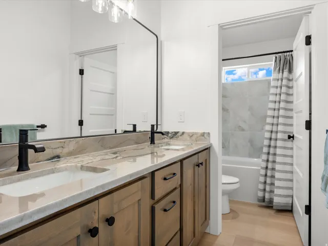 Bathroom featuring a double vanity with stone countertops and undermount sinks