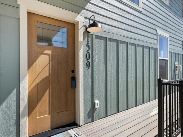 Wood-finish entry door with clear glass transom, framed by white trim