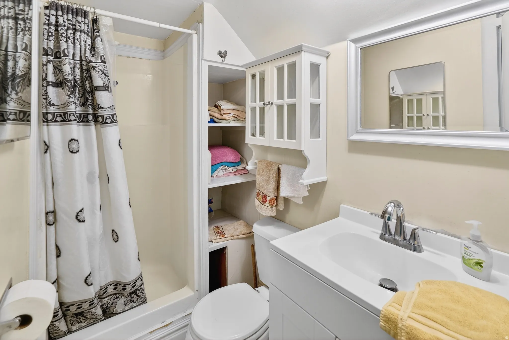 Full bath with a shower stall and vanity