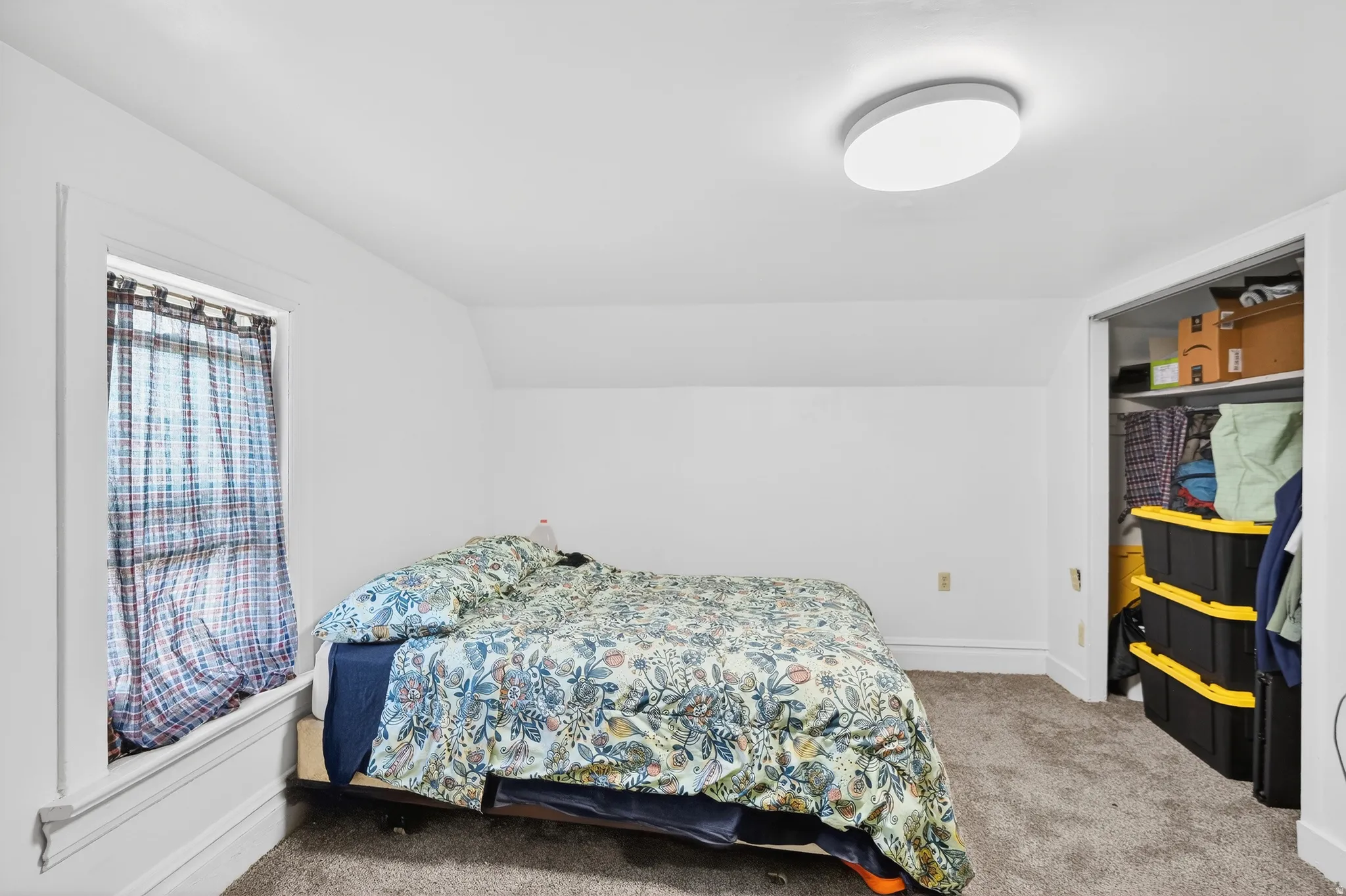 Bedroom featuring light carpet and lofted ceiling