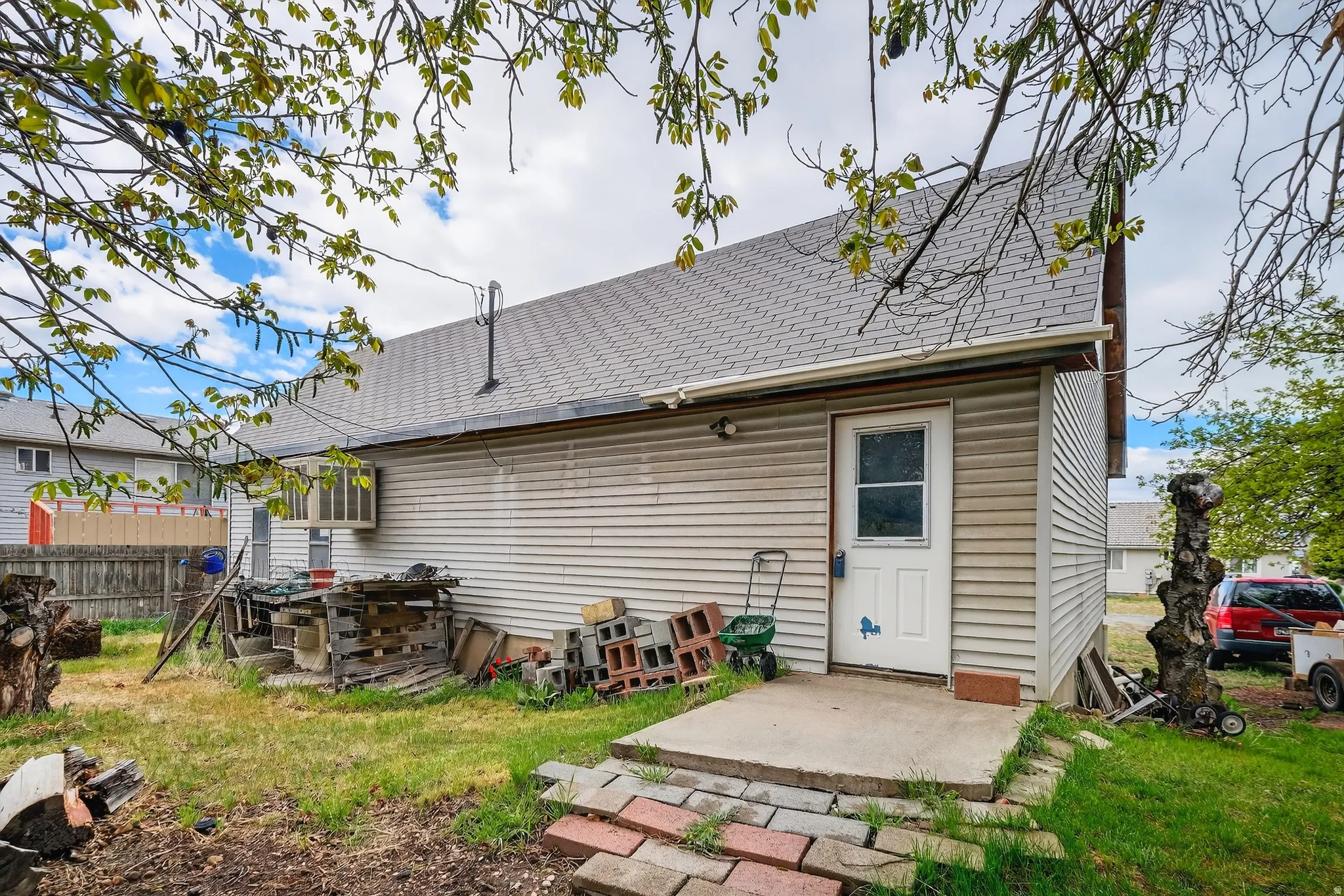 Back of house featuring a patio area and roof with shingles