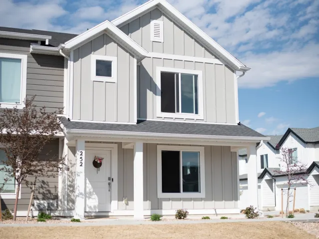 Modern inspired farmhouse with board and batten siding, a shingled roof, and covered porch