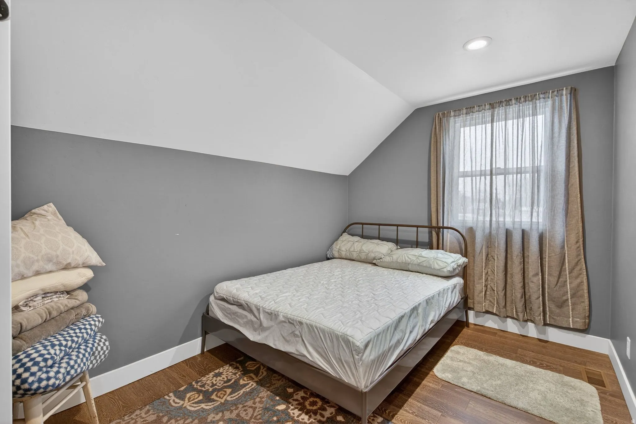 Bedroom with vaulted ceiling and wood finished floors
