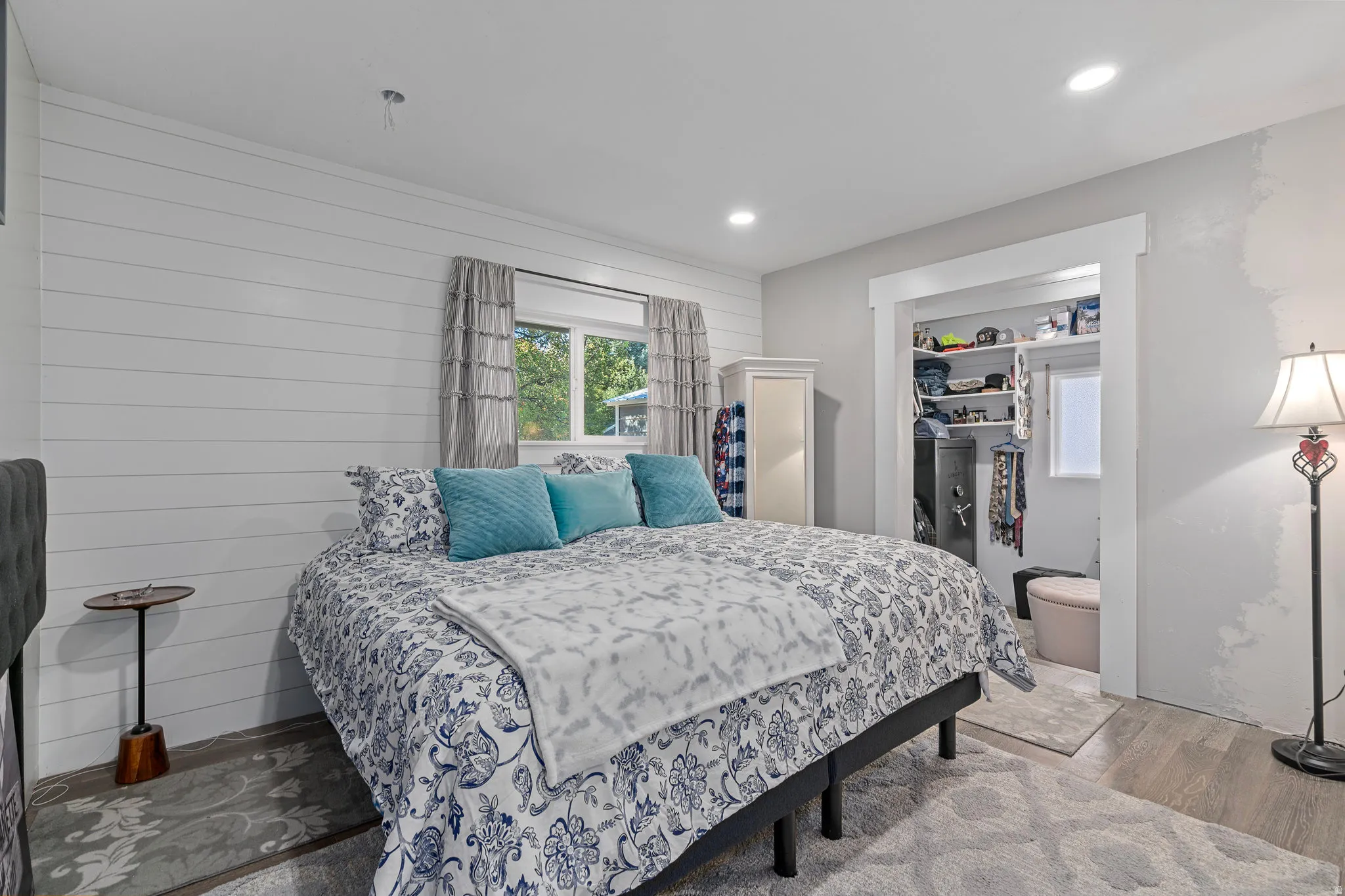 Bedroom featuring wood finished floors, recessed lighting, and wood walls