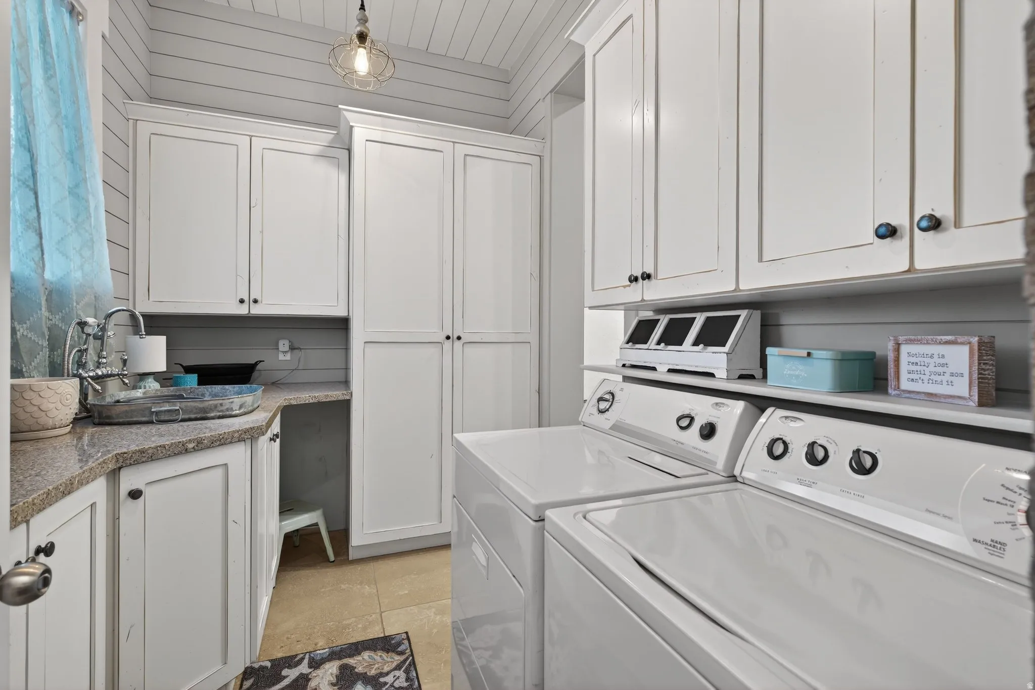 Laundry room featuring independent washer and dryer, cabinet space, and light tile patterned floors