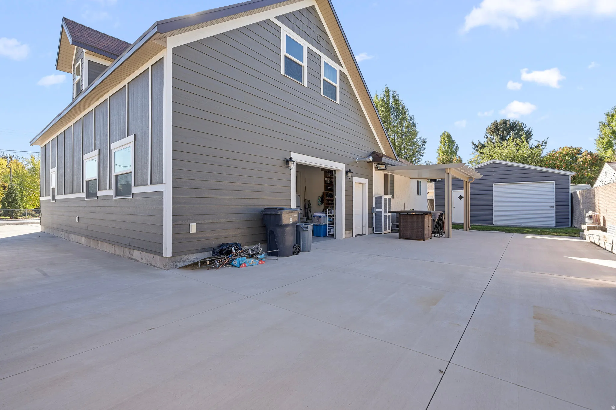 View of side of property with an outdoor structure and concrete driveway