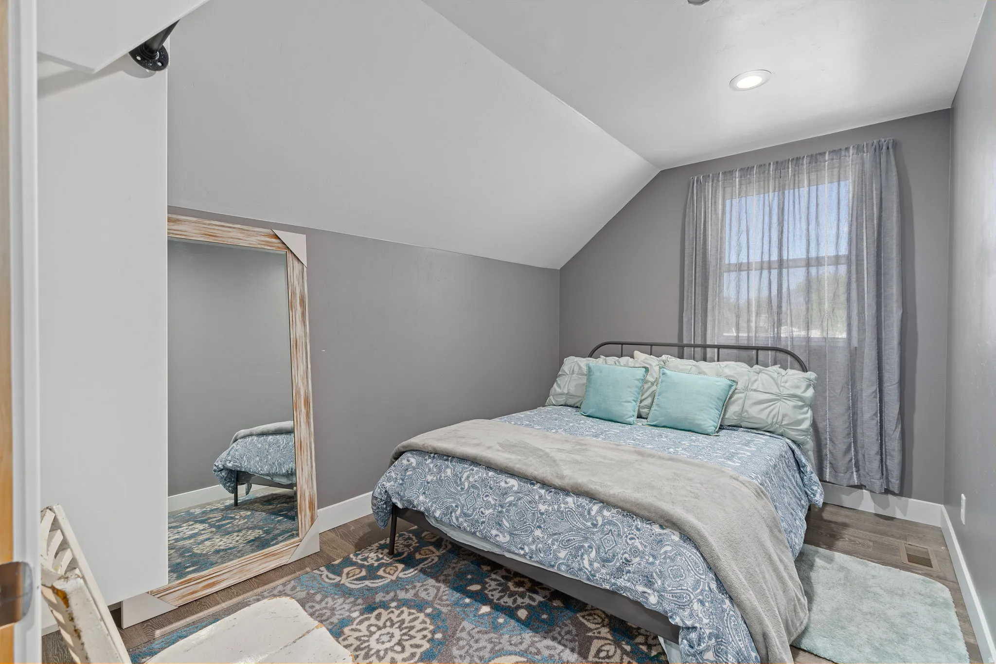 Bedroom featuring lofted ceiling and wood finished floors