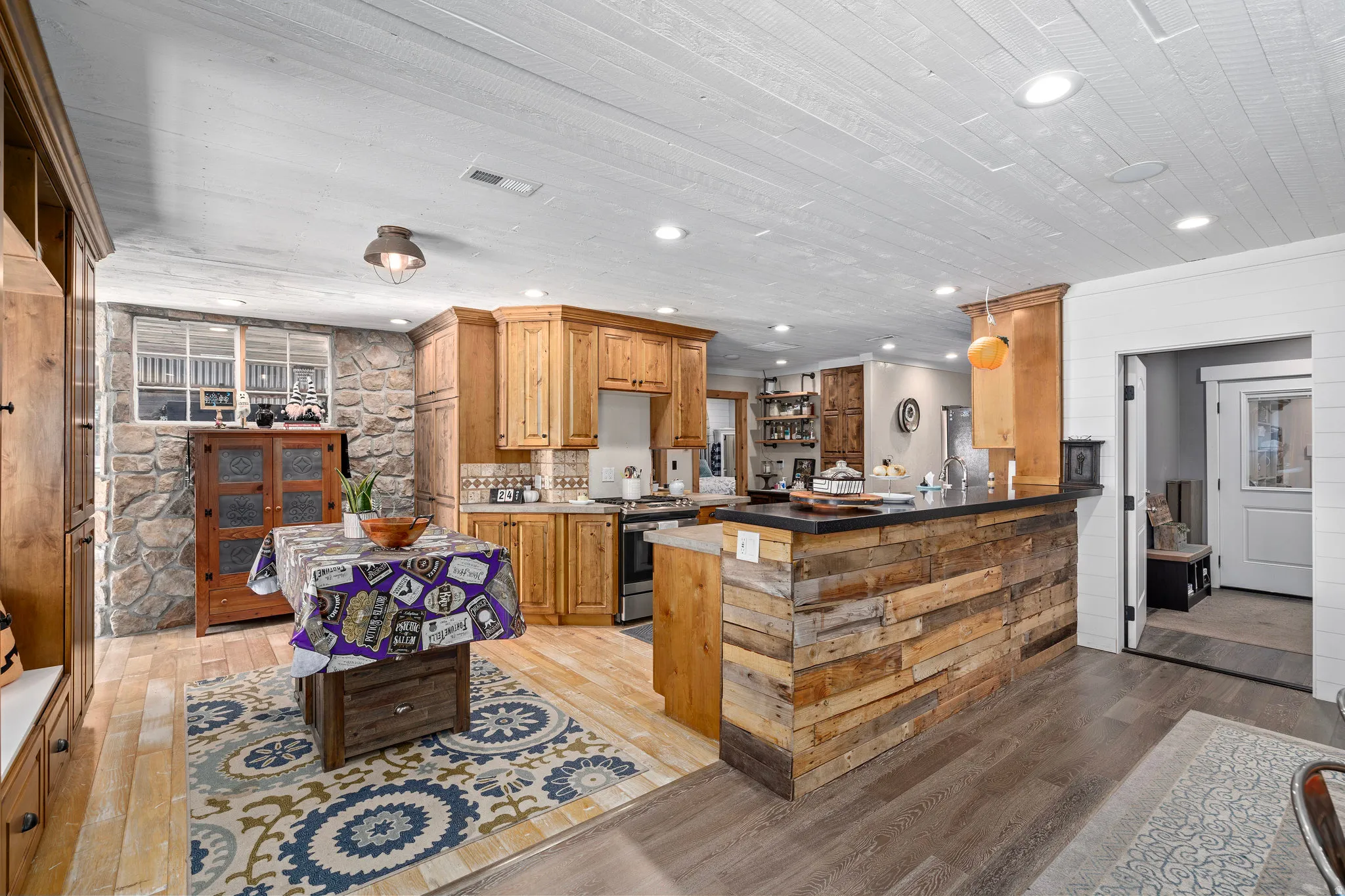 Kitchen featuring light wood-type flooring, stainless steel gas range oven, wood finish cabinetry, tasteful backsplash, and recessed lighting