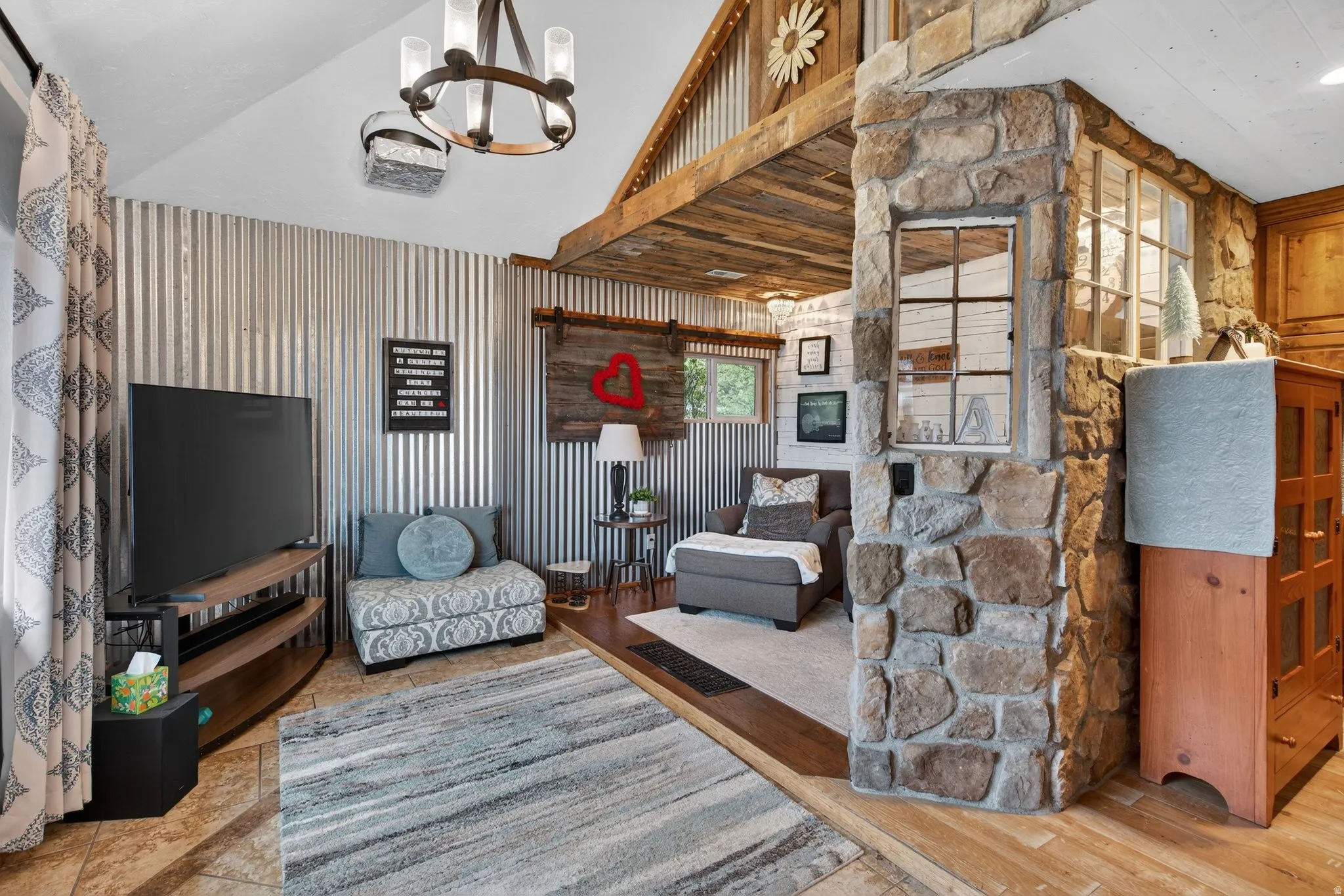 Living area with lofted ceiling, light wood-style floors, and hanging lights