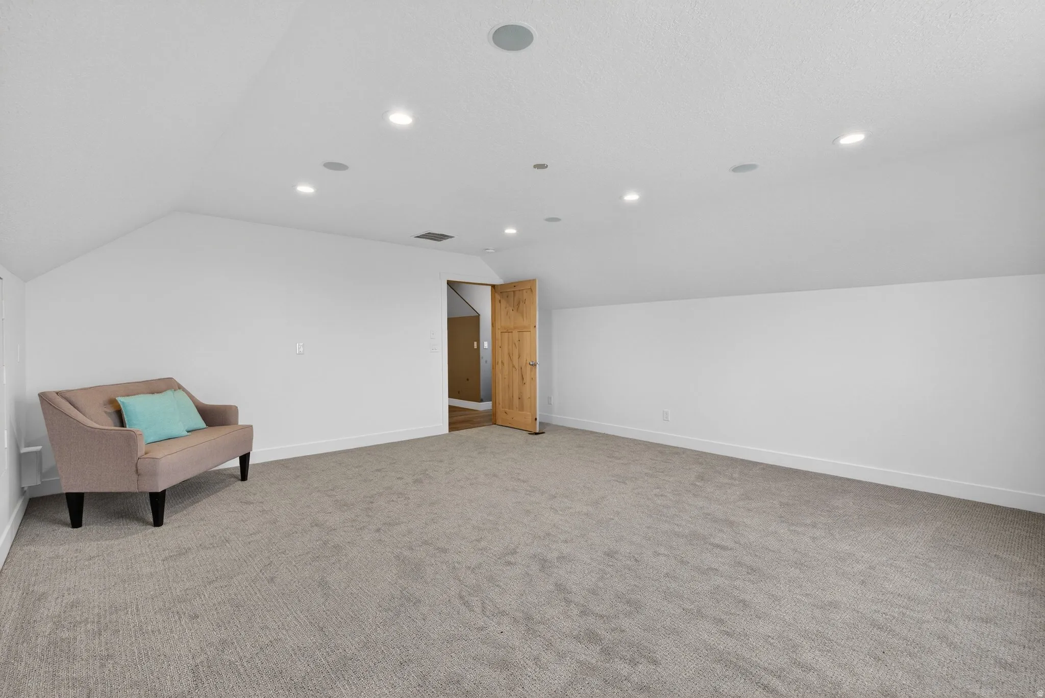 Bonus room featuring vaulted ceiling, light colored carpet, and recessed lighting