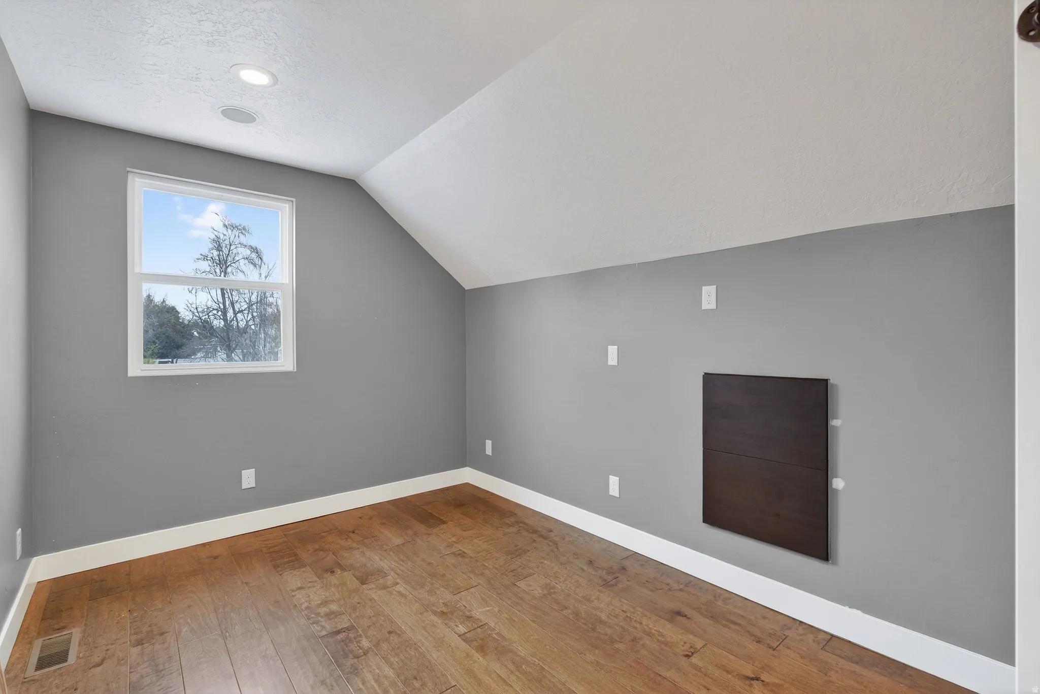 Additional living space with baseboards and light wood-style floors