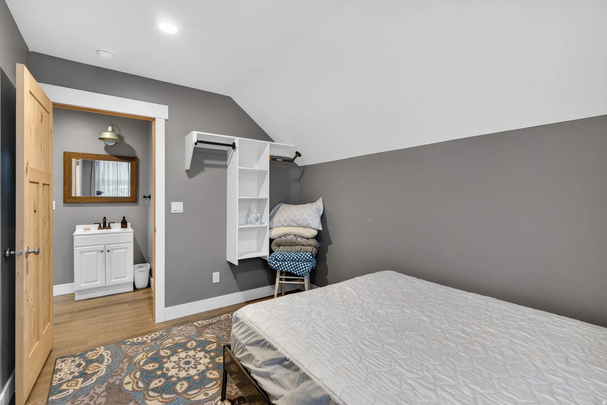 Bedroom featuring vaulted ceiling and light wood-style floors