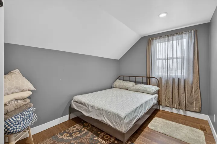 Bedroom with vaulted ceiling and wood finished floors