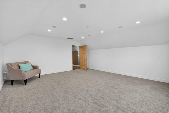 Bonus room featuring vaulted ceiling, light colored carpet, and recessed lighting