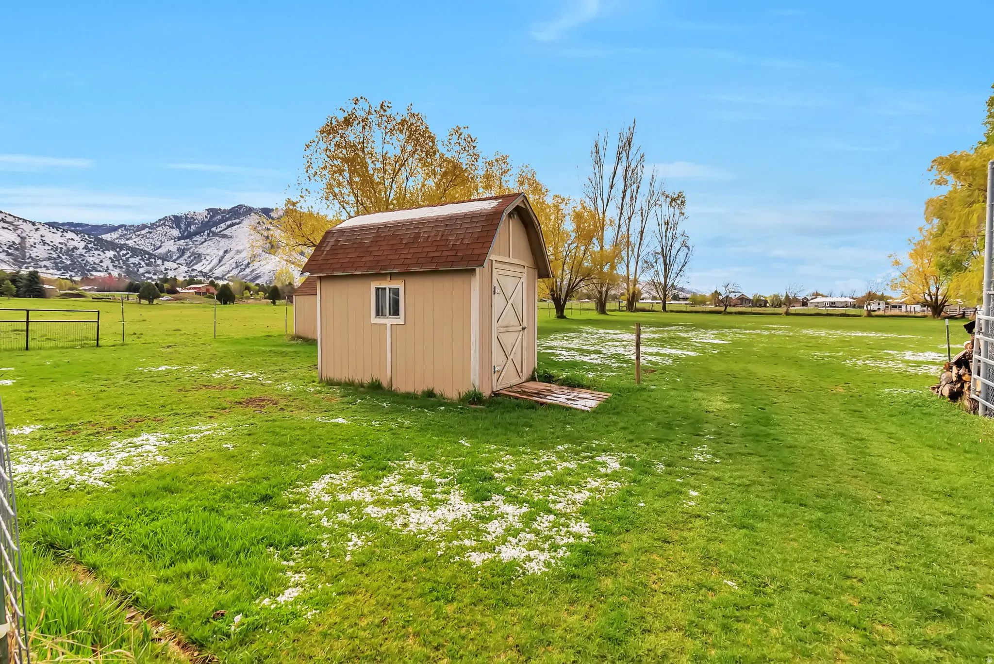 View of grassy yard featuring a storage unit and a mountain view