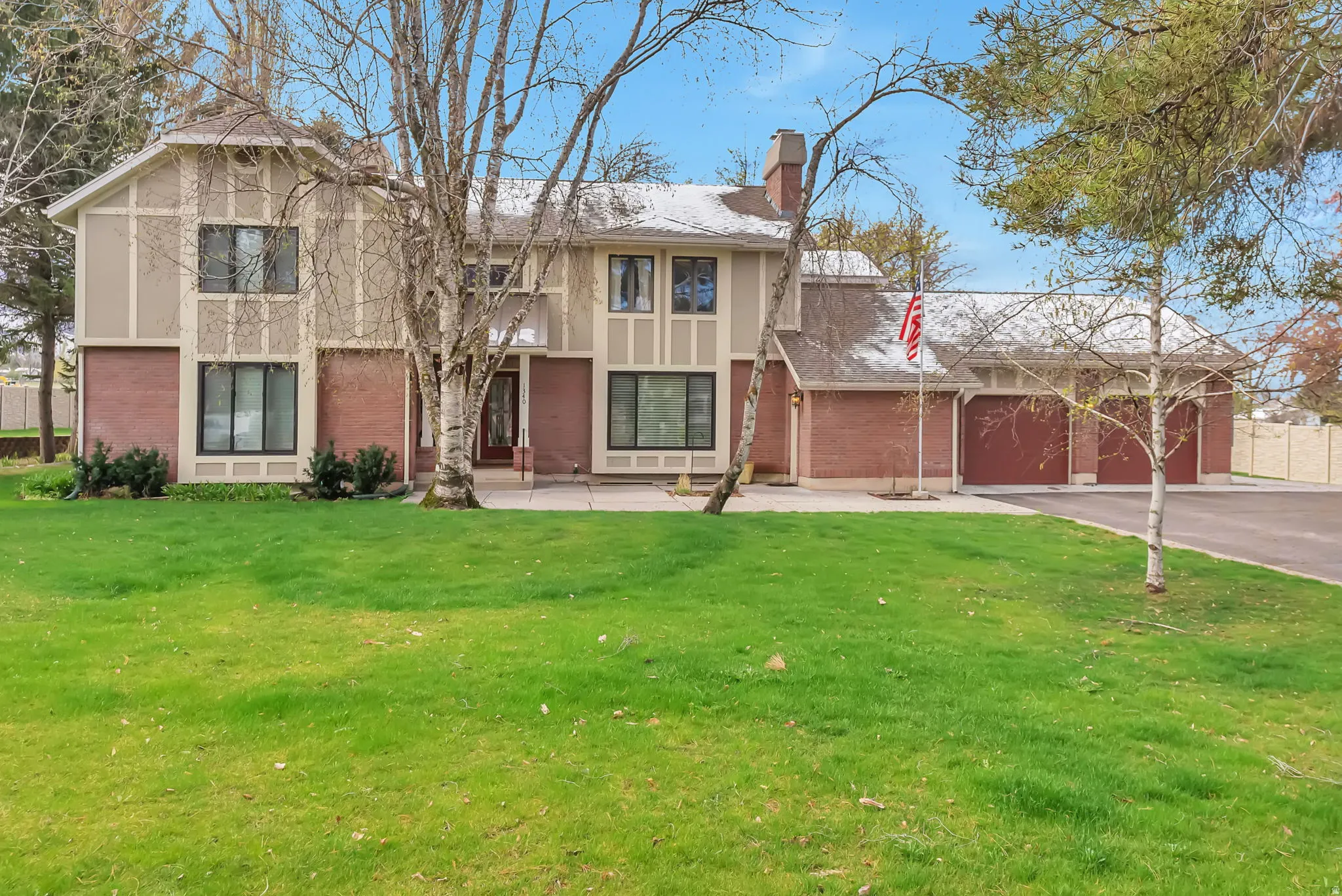 View of front of house featuring brick siding, driveway, and a front yard