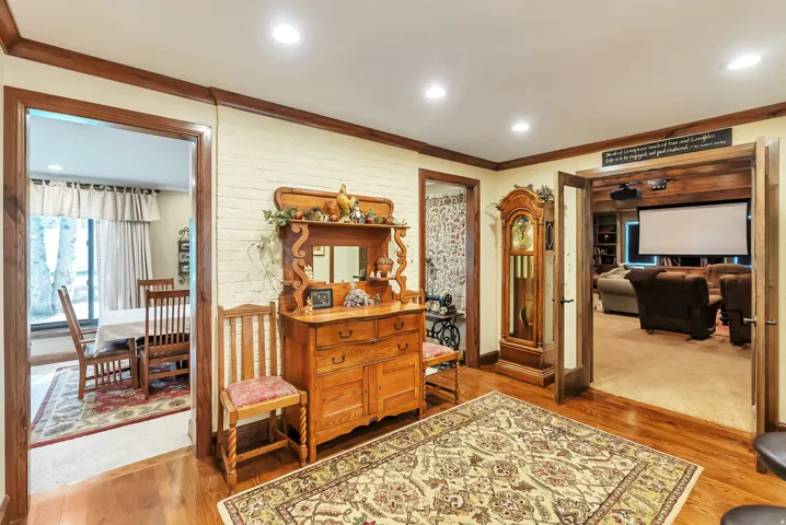 Sitting room with light wood-type flooring, ornamental molding, and recessed lighting