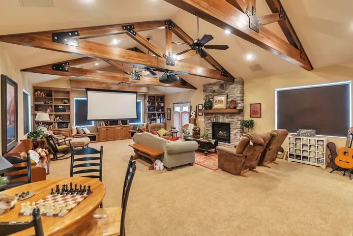 Living area featuring light carpet, built in features, recessed lighting, a fireplace, and ceiling fan