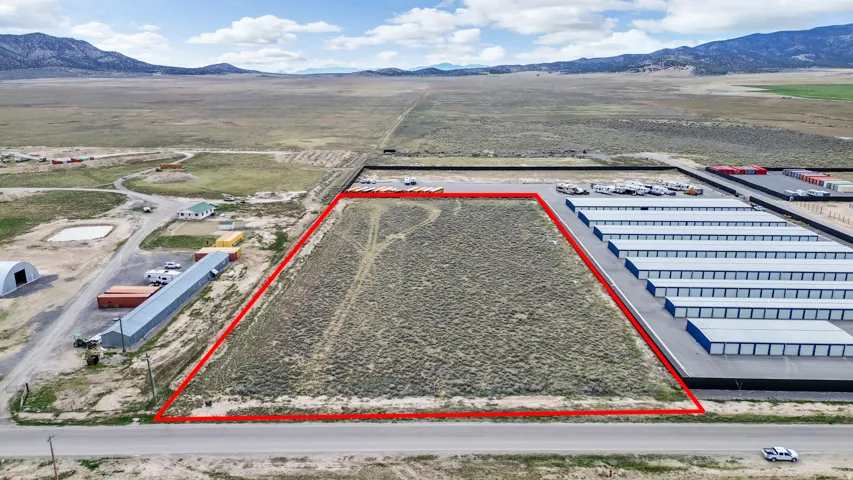 Aerial overview of property's location featuring a mountainous background and property boundaries highlighted