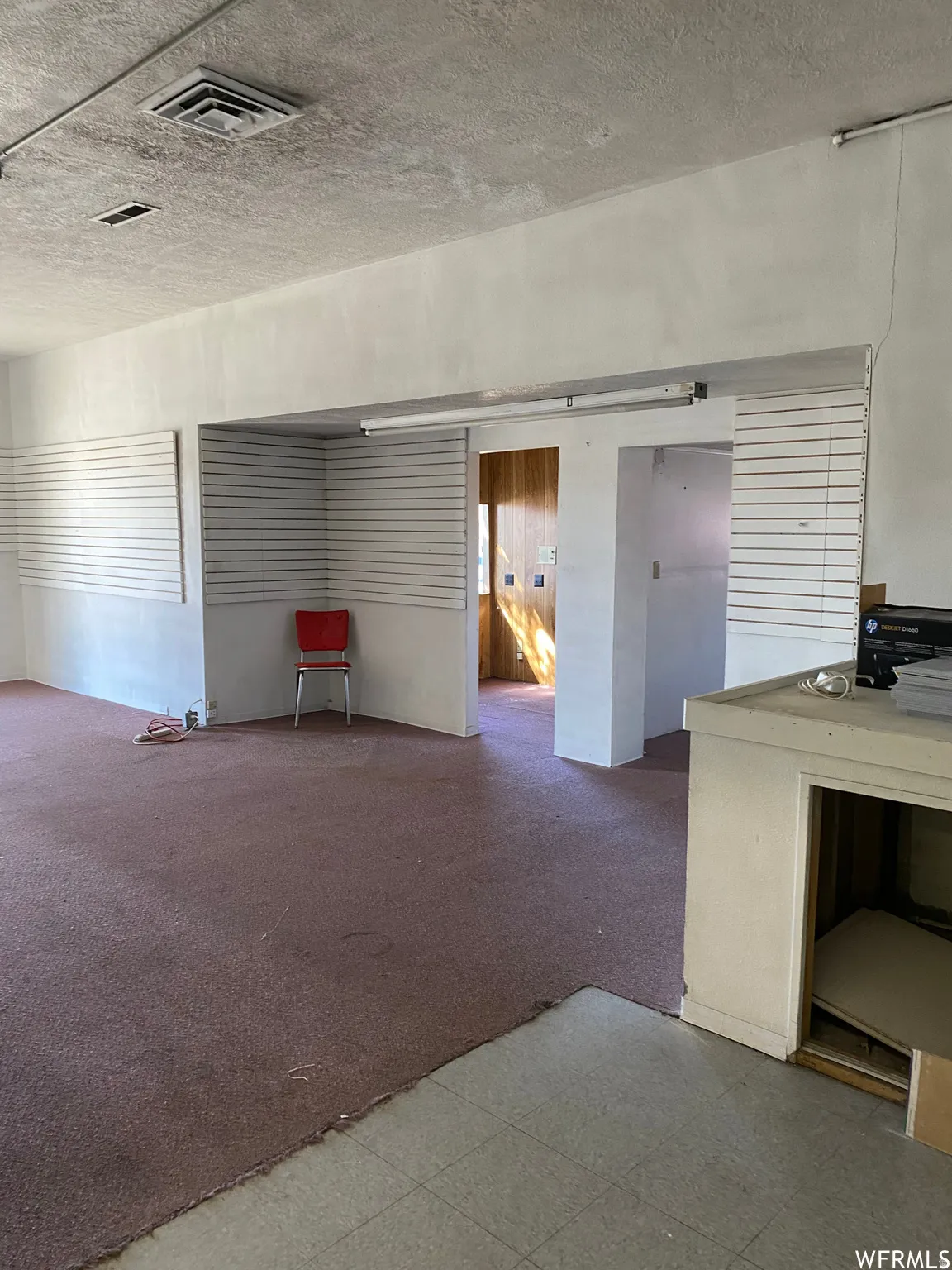 Unfurnished room with carpet and a textured ceiling