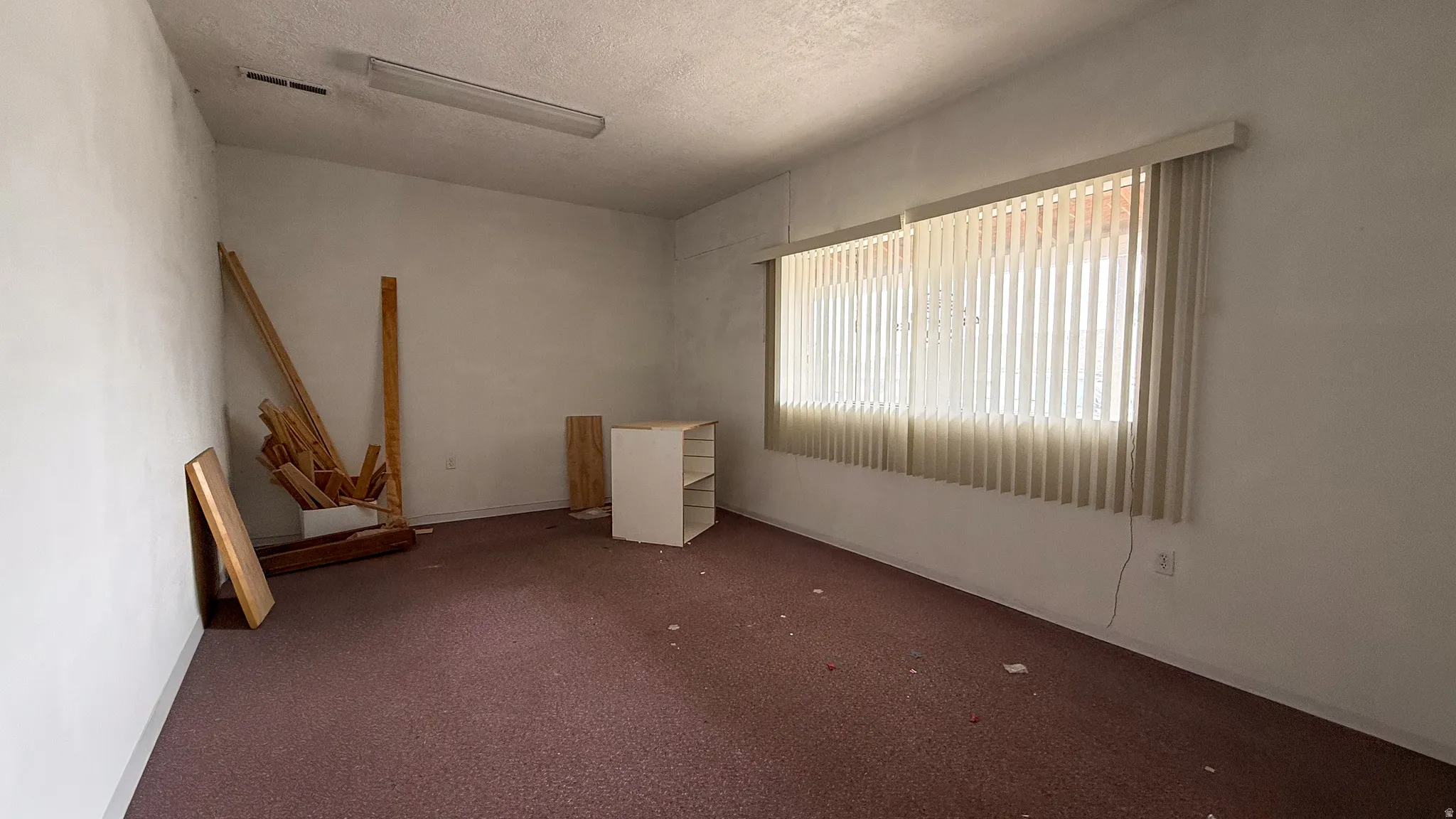 Carpeted spare room featuring a textured ceiling