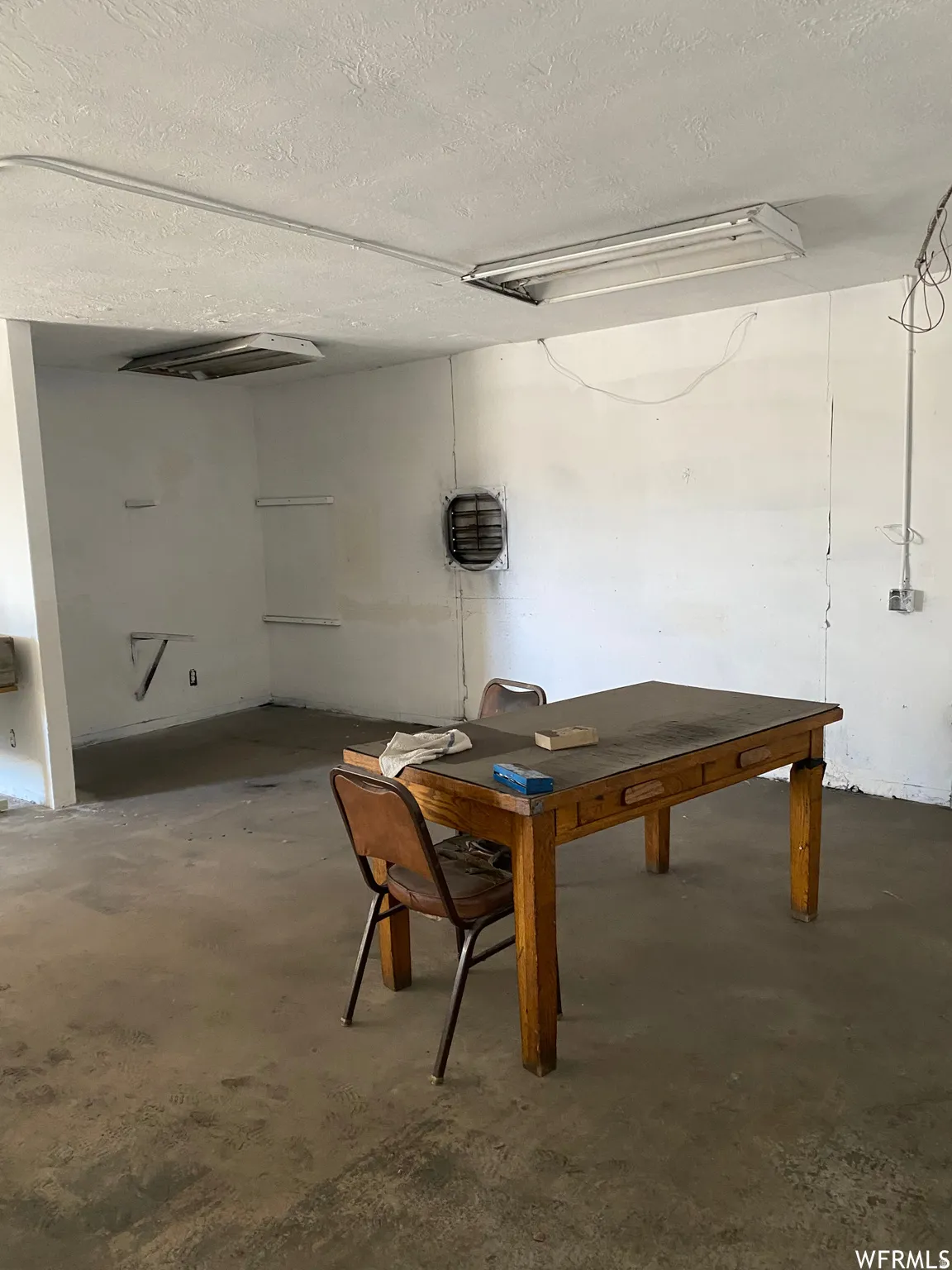 Dining space featuring concrete flooring and a textured ceiling
