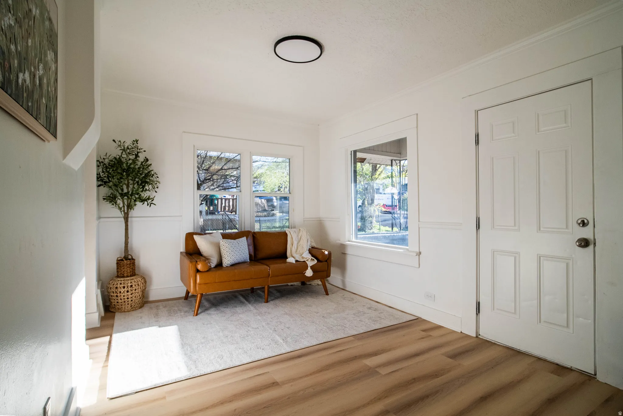 Sitting room featuring wood finished floors and crown molding