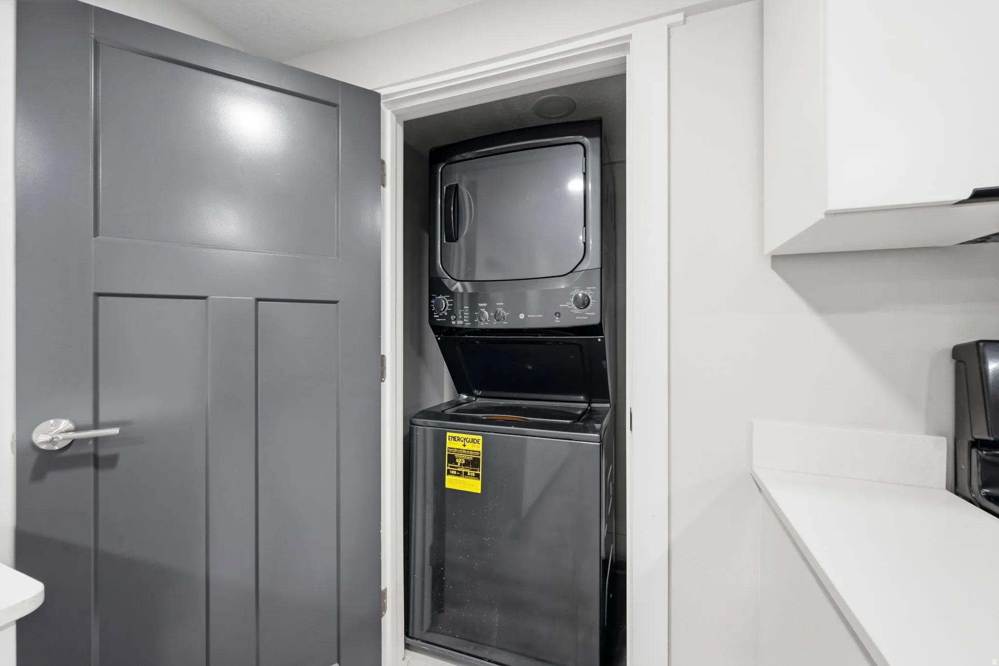 Laundry area with stacked washer and dryer