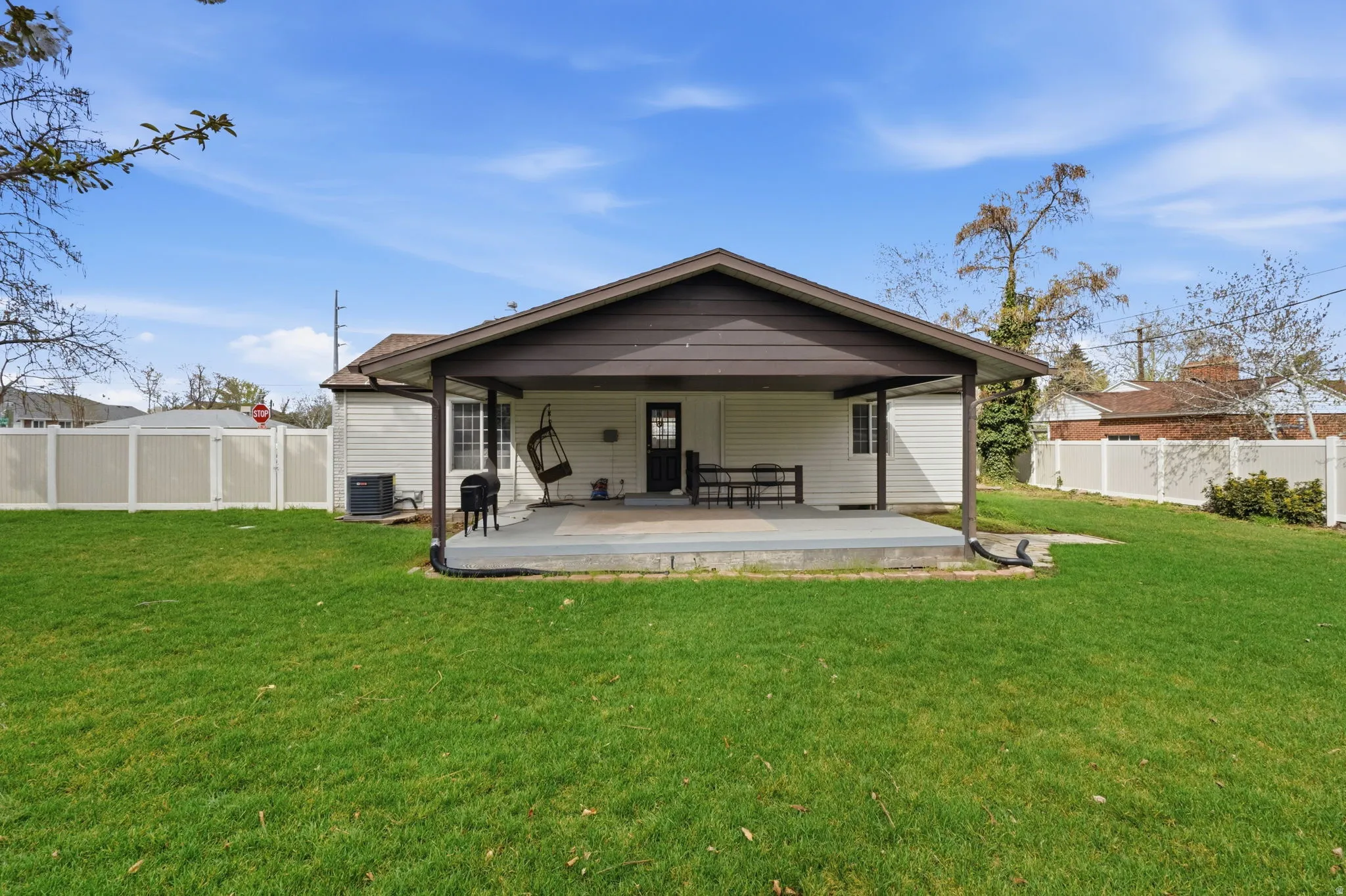 Rear view of house featuring a fenced backyard and a patio