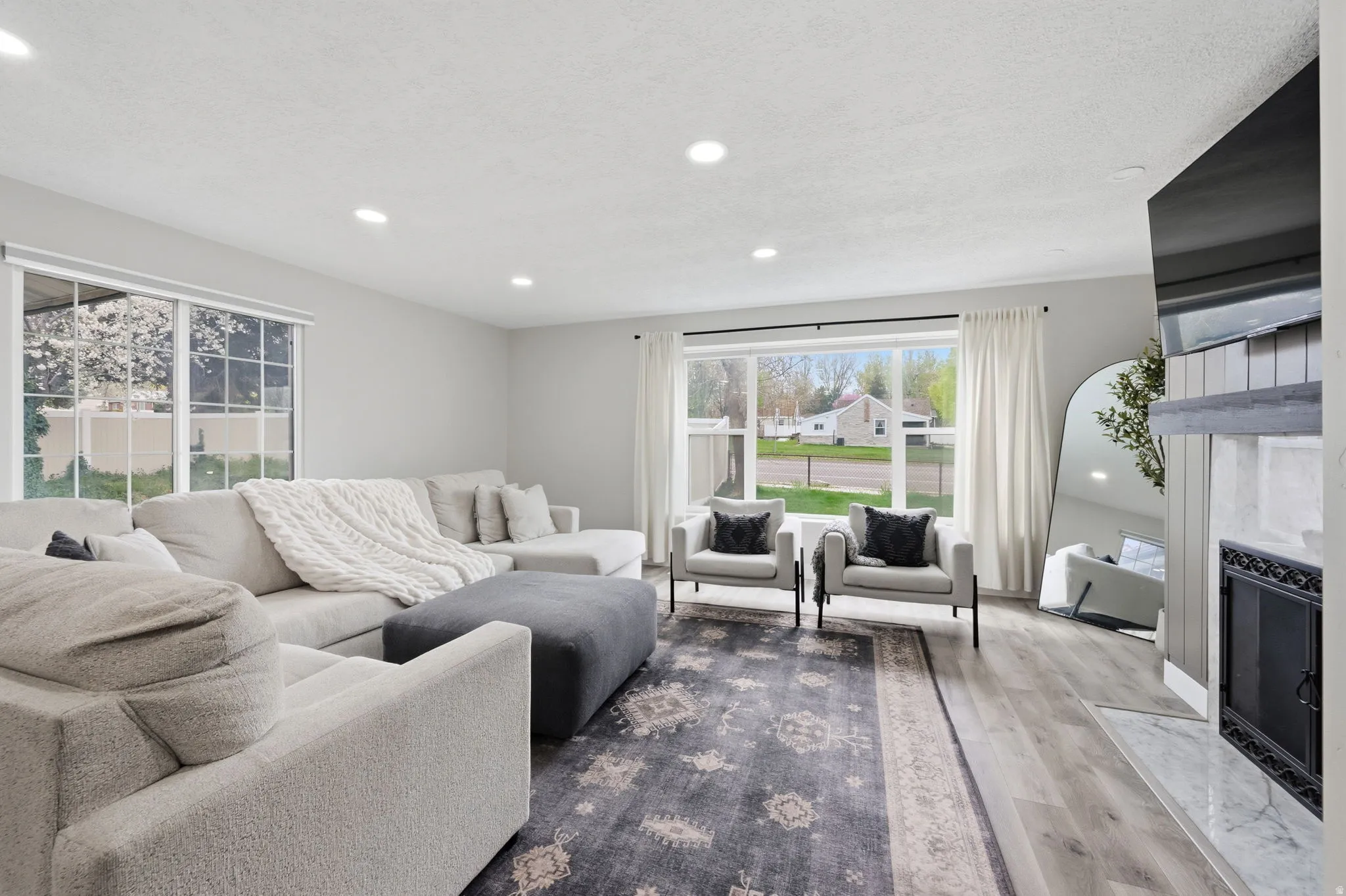 Living area with a premium fireplace, wood finished floors, and recessed lighting