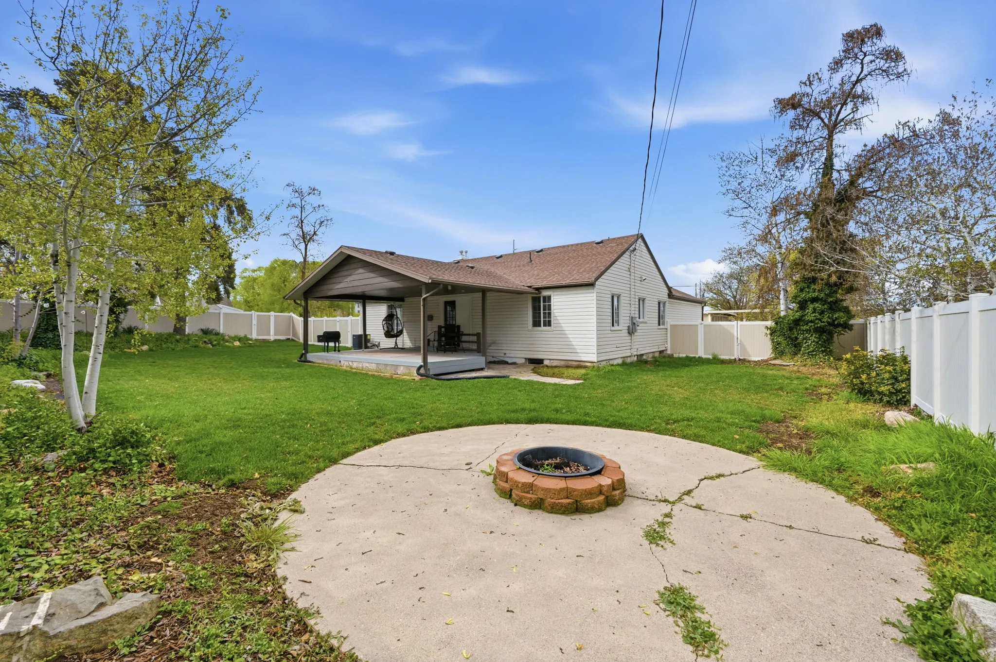 Rear view of property with a fenced backyard, a patio area, a fire pit, a shingled roof, and crawl space