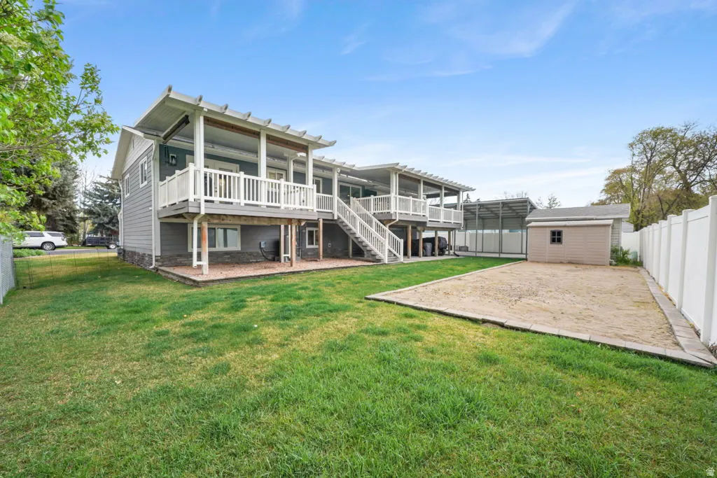 Rear view of house featuring AGAIN the BIG DECK, with a shed and fenced backyard.