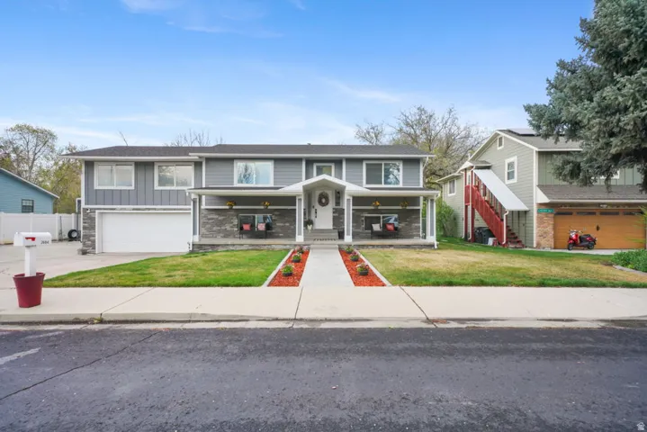 Front of property featuring covered porch, a front lawn, board and batten siding, a garage, and driveway
