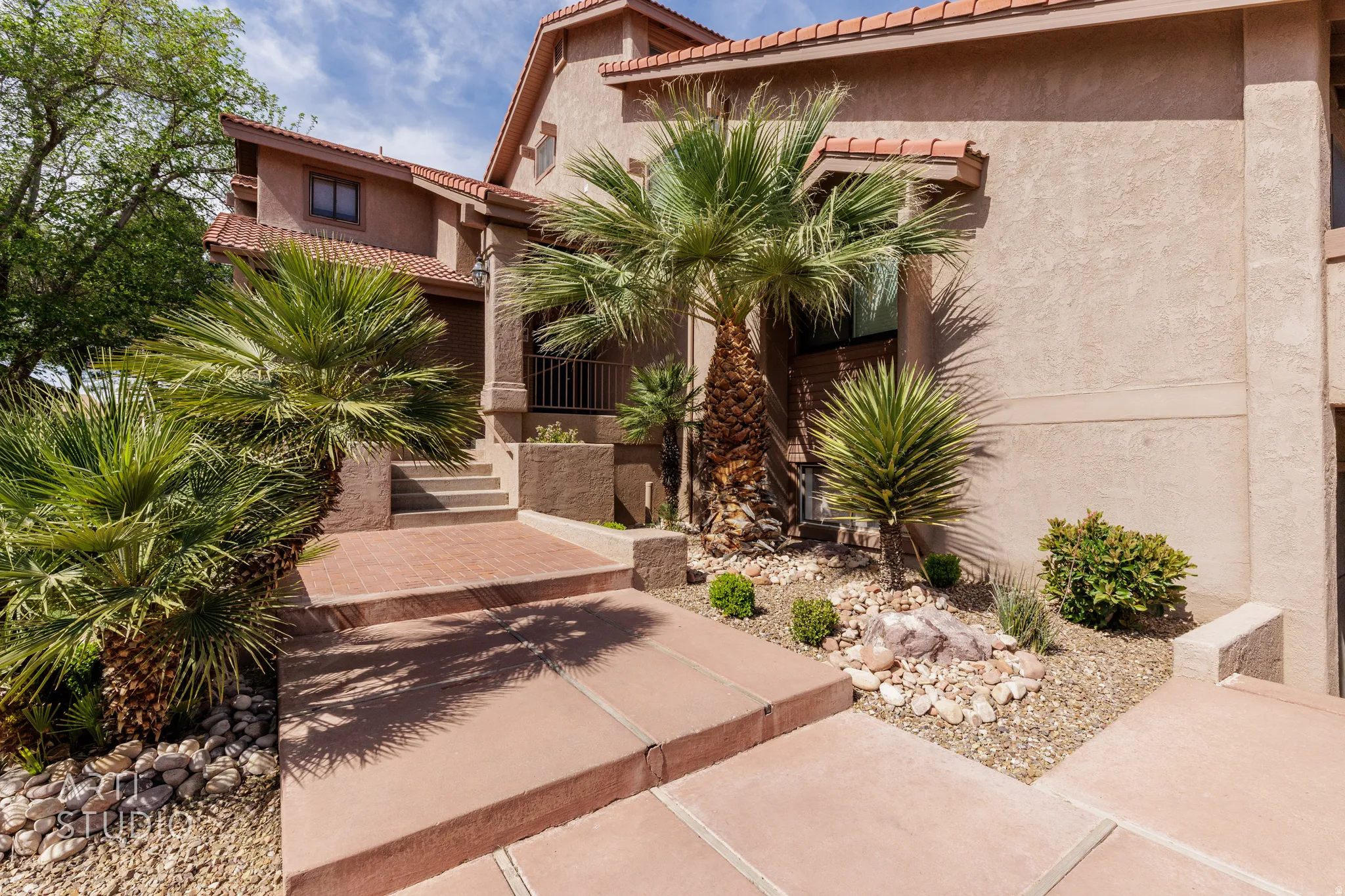 View of front of house with a tiled roof and stucco siding
