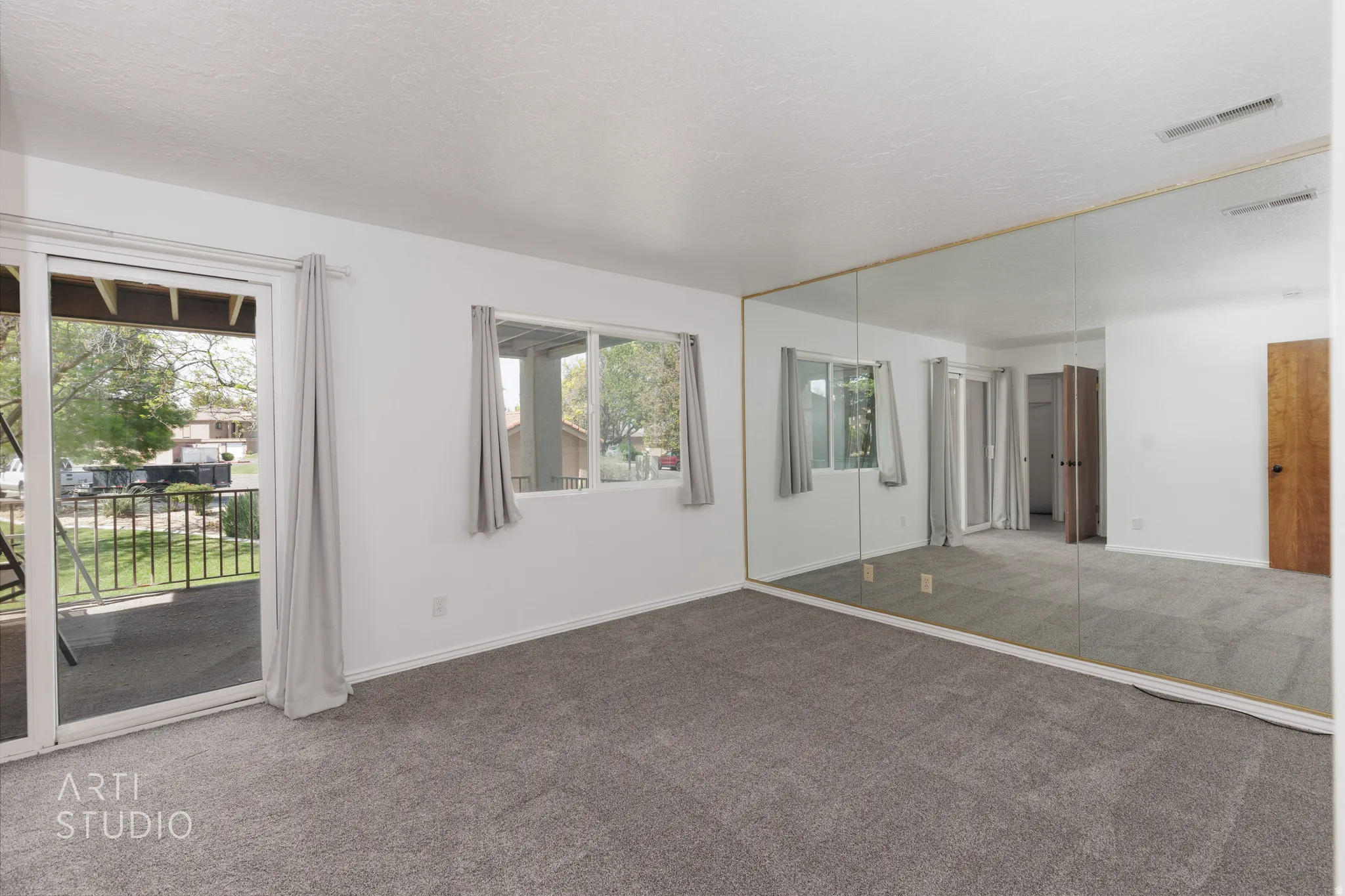 Unfurnished bedroom with carpet floors, a closet, access to exterior, and a textured ceiling