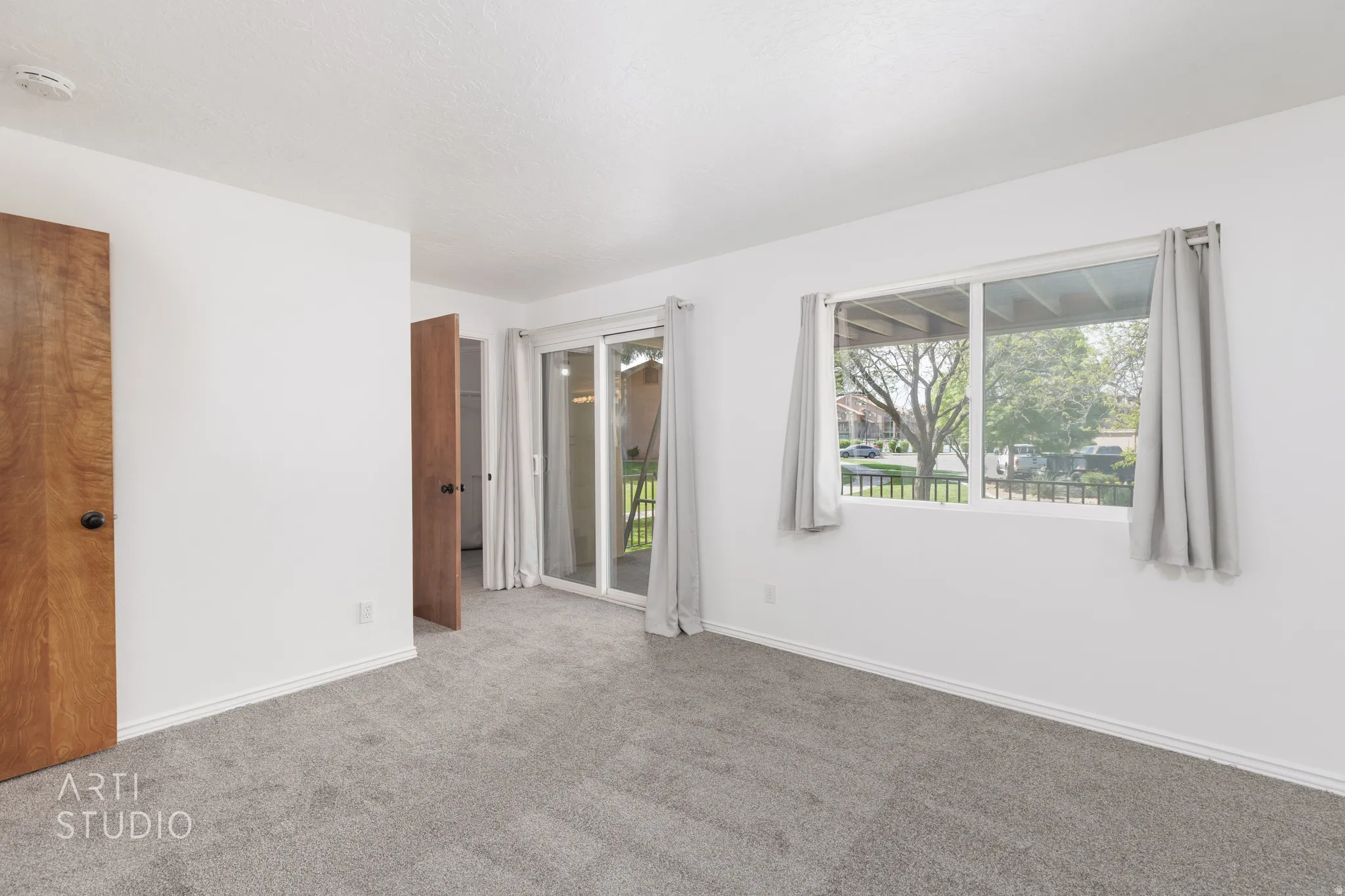 Unfurnished bedroom featuring access to outside and carpet floors