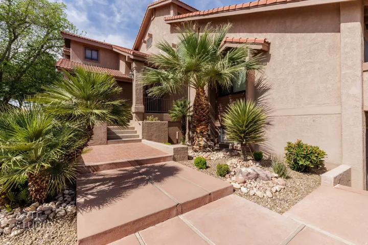 View of front of house with a tiled roof and stucco siding