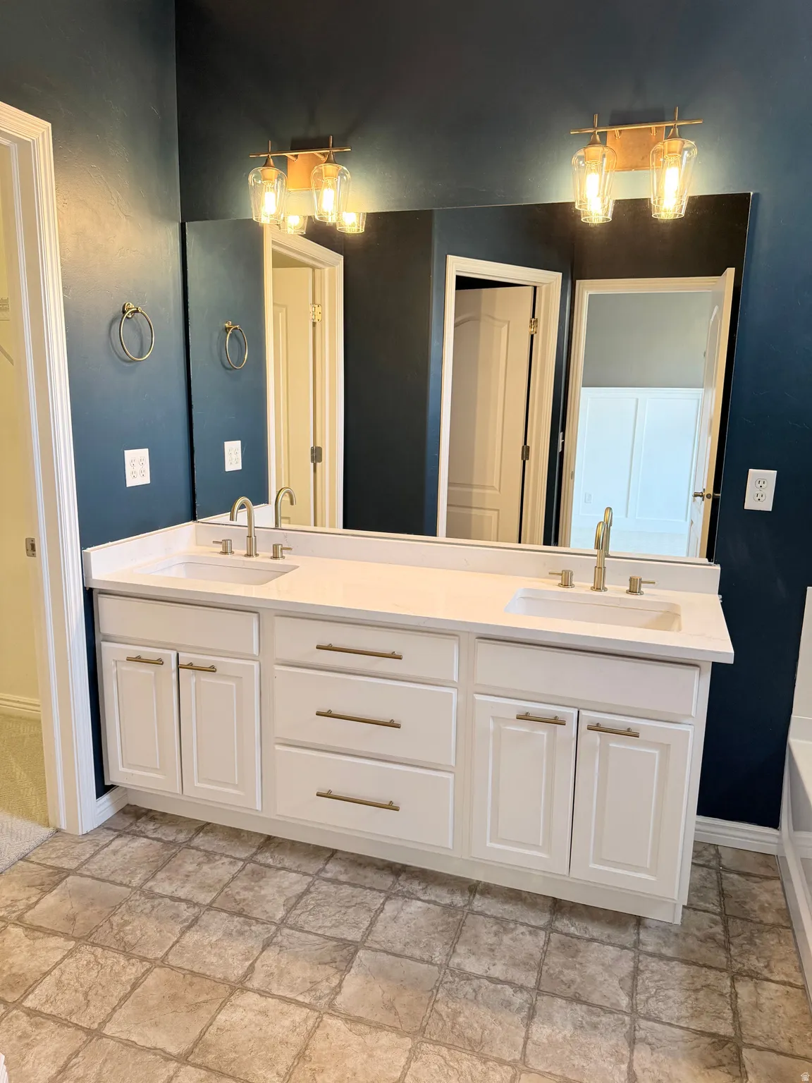 Full bathroom with double vanity and stone finish flooring