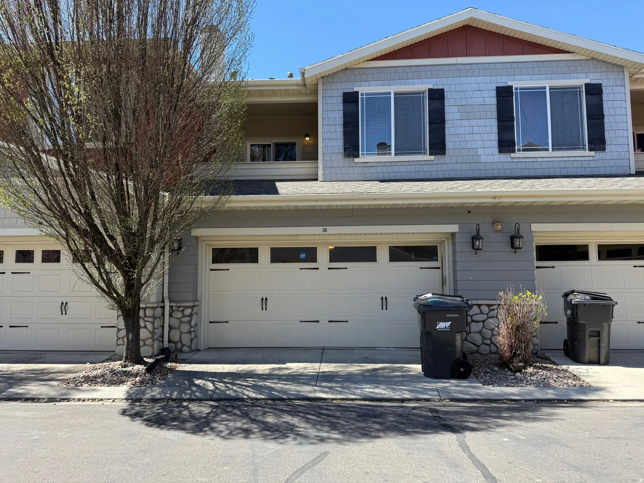 View of front of house with a shingled roof, an attached garage, and driveway