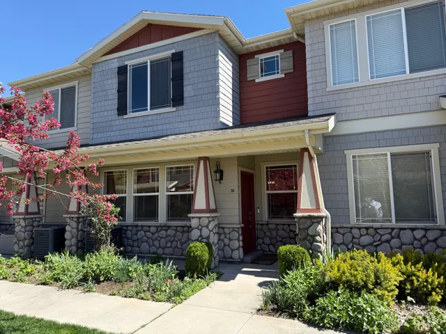 Craftsman-style home featuring stone siding and a porch
