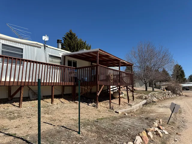 Expansive wood-finish deck with a covered section, offering outdoor living space