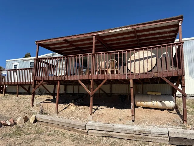 Expansive raised deck with a full railing and a covered patio roof
