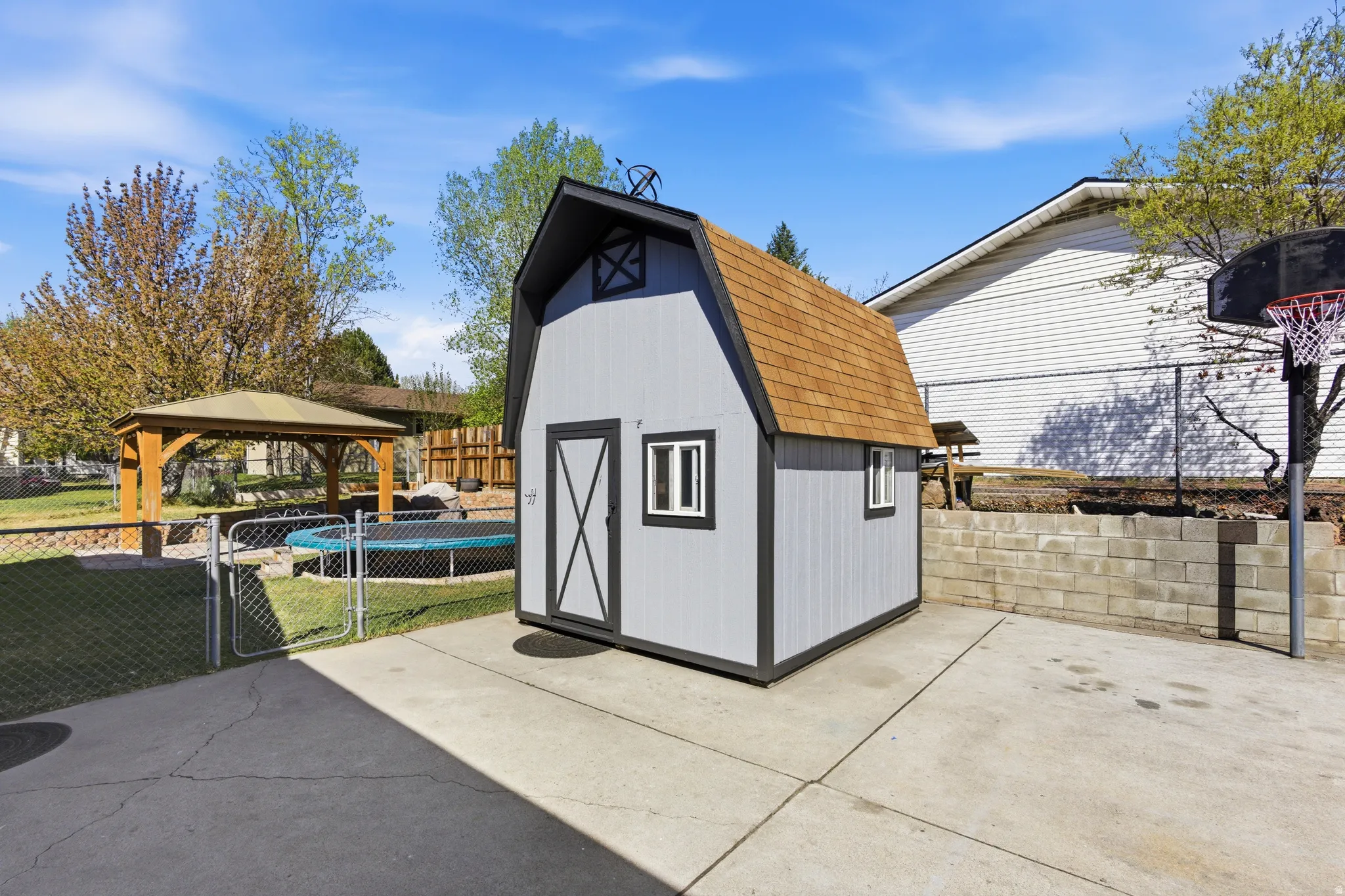 View of shed with a gazebo, a fenced backyard, and a gate