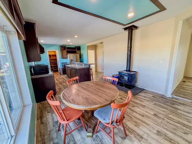 Dining area featuring light wood-style flooring, a wood stove, and recessed lighting