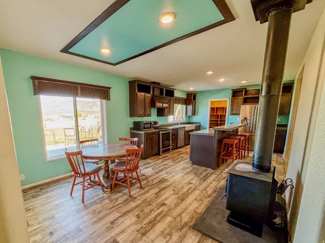 Dining room featuring a wood stove, light wood-style floors, and recessed lighting