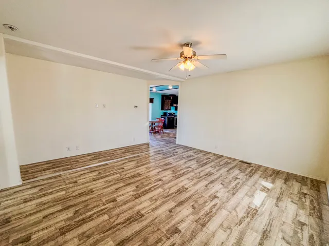 Empty room featuring a ceiling fan and light wood finished floors