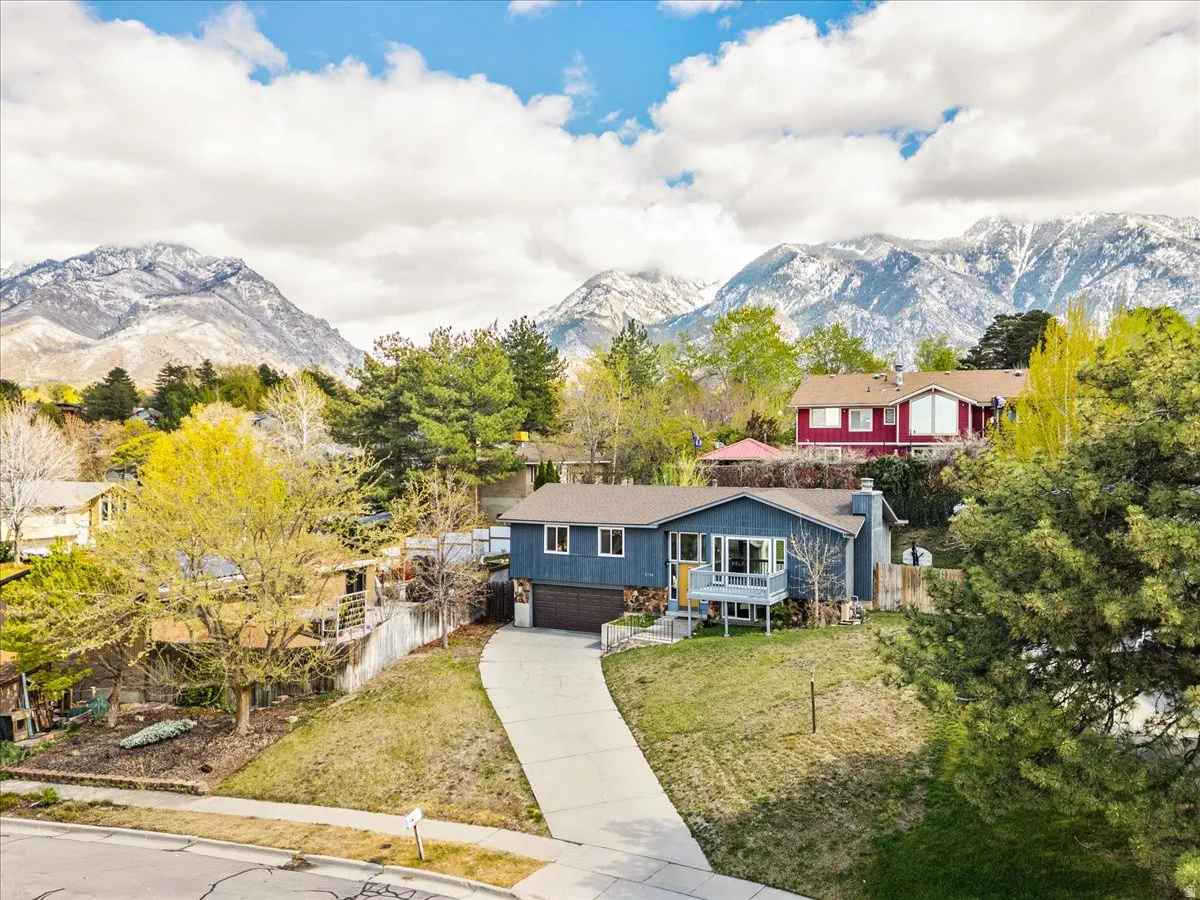 View of front of property with an attached garage, driveway, and a mountain view