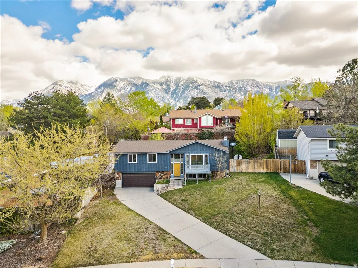 View of front of home with a garage, driveway, and a mountain view