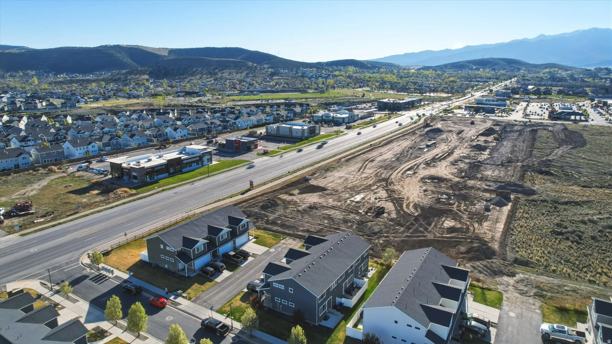 Aerial overview of property's location with nearby suburban area and a mountain backdrop