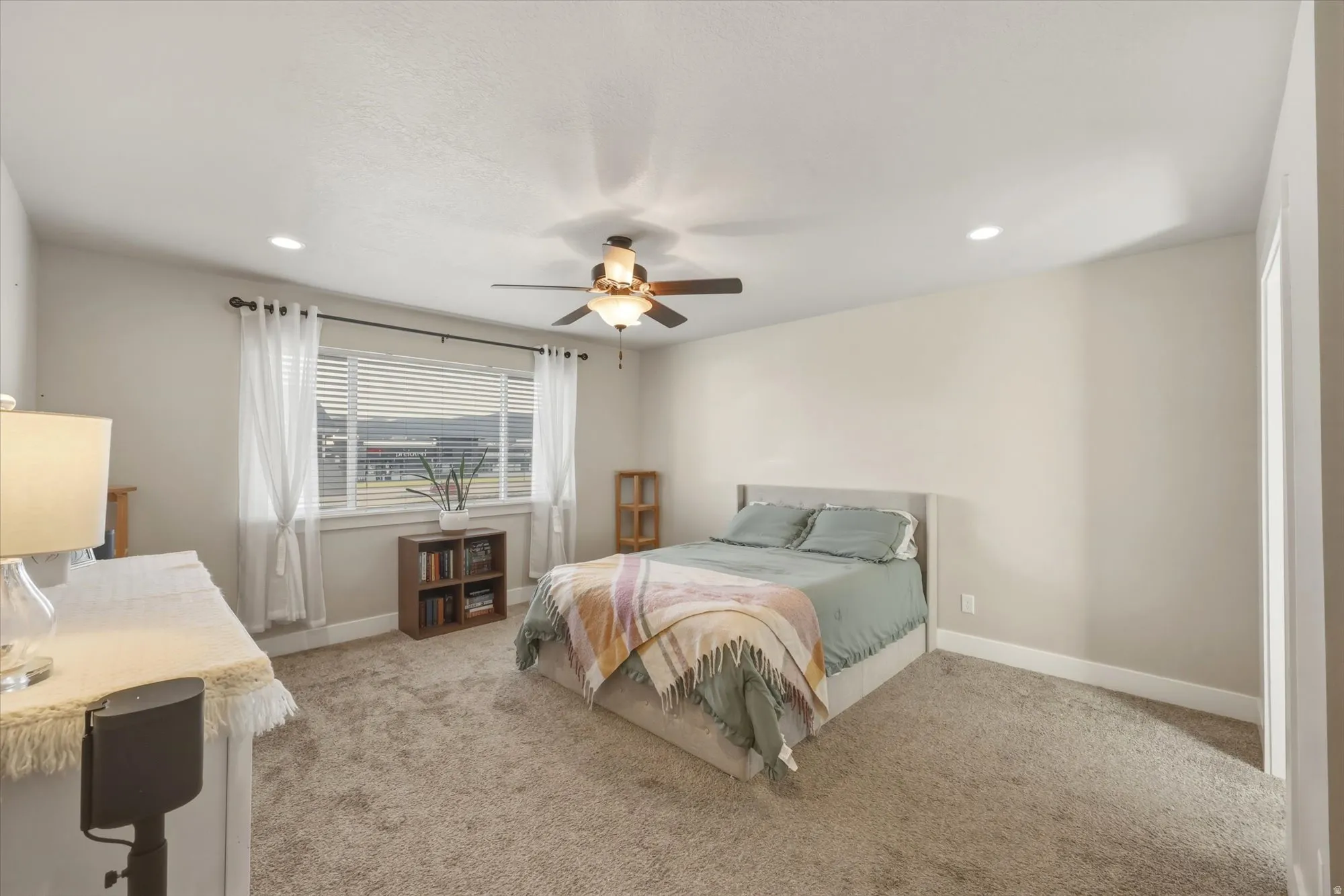 Bedroom with light colored carpet, recessed lighting, and a ceiling fan